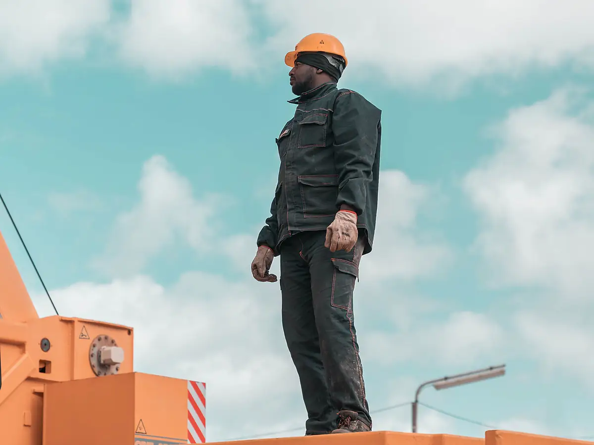 Worker standing on the deck of a mobile crane